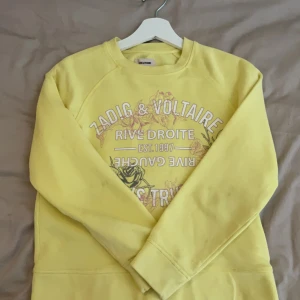 Gul sweatshirt Zadig & Voltaire XS - Gul sweatshirt från Zadig & Voltaire med tryck i vitt och gult framtill. Tröjan har rund hals, långa ärmar och är gjord i mjuk bomull. Perfekt för dig som gillar färg och vill sticka ut lite extra.