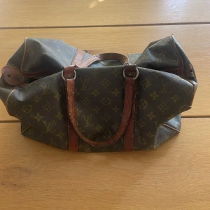 Louis Vuitton väska  - Riktigt fin vintage Louis Vuitton väska! Helt äkta men har inte kvitto eller liknande eftersom att den är väldigt gammal(70-80 tal) Pris kan diskuteras. 