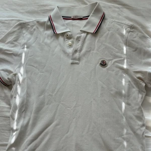 Vit moncler piké  - Otroligt snygg piké från moncler, mycket stilren, bra skick! Den är M men skulle säga att den passar bättre S