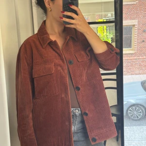 Brun manchesterjacka från Selected Homme - Säljer en brun manchesterjacka från Selected Homme. Jackan har klassisk krage, stora bröstfickor med lock och knäppning framtill med svarta knappar. Overshirt-modell med raka linjer och lång ärm, perfekt för lager-på-lager-stil.