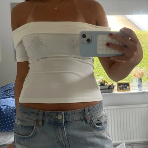 Vit offshoulder topp i stretchigt tyg - Säljer en vit offshoulder topp med croppad passform. Knappt använd!!!💓🙌