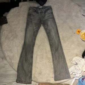 Grå bootcut jeans från Gina Tricot - Snygga grå jeans från Gina Tricot i bootcut-modell. Jeansen har markerade bakfickor med vit kontrastsöm. Klassisk femficksdesign och tillverkade i jeansmaterial. Perfekta för dig som gillar en avslappnad och trendig look. Skriv privat för fler bilder, vi kan sy ihop hålet längst ner❣️