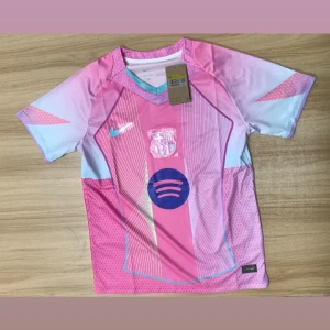 Barça x Nike rosa fotbollströja S - Barcelona x Nike fotbollströja i rosa och ljusblå toner med vita linjer och detaljer. Kortärmad, Dri-FIT-material som andas, V-ringad krage med turkos kant. Tryckt klubbmärke och Spotify-logga på bröstet. Perfekt för dig som vill sticka ut på planen.