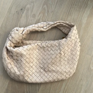 Beige handväska flätad - Säljer en beige handväska som är flätad. Köpt i Thailand och liknad bottega. I bra skick. 