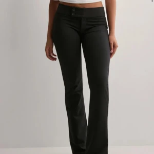 Lågmidjade kostymbyxor   - Lågmidjade kostymbyxor från nelly med en knapp design i fram och utan fickor i bak. Säljer pga att de inte kommer till användning längre