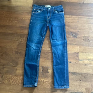 Levi's 512 blå jeans straight fit - Säljer ett par Levi's 512 jeans i klassisk blå färg med snygga kontrastsömmar och fem fickor. Modellen har rak passform och normal midja, tillverkad i slitstarkt denim. Perfekt för dig som gillar tidlös stil och vill ha ett par jeans som funkar till allt.