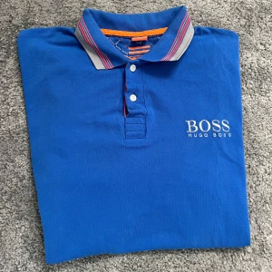 Hugo Boss piké - Säljer en blå piké från Hugo Boss. Storleken är xxl men den sitter som L. Skicket är bra på den