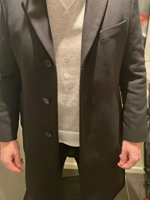Hugo Boss cashmere-wool rock - Säljer min stilrena Hugo Boss rock i strl De 48 (M), använd fåtal gånger men har en liten skräddarsydd lagning vid ena fickan (syns inte vid användning). Köptes för ungefär 8 år sedan för runt 6000kr 
