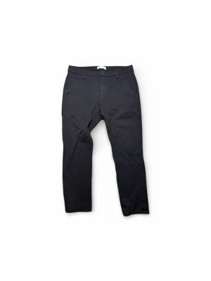 Svarta kostymbyxor från Dondup - Svarta kostymbyxor från Dondup, tillverkade i Italien. Byxorna har klassisk rak passform med bälteshällor, sidfickor och bakfickor med knapp. Materialet är mjukt och har en lätt stretch för extra komfort. Perfekt för en clean och stilren look.