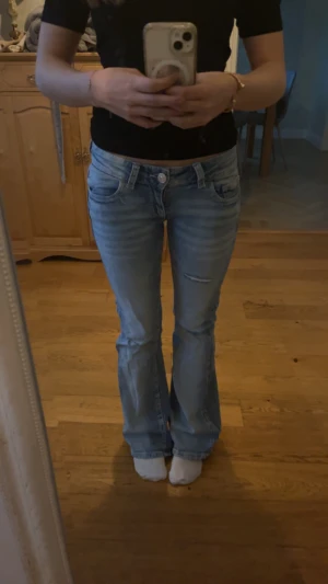 Low waist jeans med slitningar - Snygga low waist jeans med slitningar, använda 2 gånger så som helt nya🥰stl Xs från Gina, passar mig som är 158 men nån cm för lång, 79 cm och midja rakt över 32 cm  