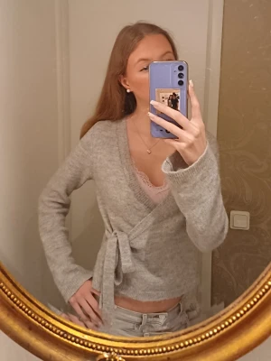 Grå kofta med knyte fram  - Supermysig grå kofta i stickad matrial med knytband i midjan. Koftan har v-ringning och långa ärmar, perfekt att ha nu på vinten när det är kallare ute ❤️ skriv om ni har några frågor 