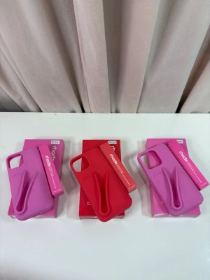 Rhode skal - Snygga och unika mobilskal från Rhode för iPhone 13 och iPhone 13 Pro. Finns i rosa och rött, med ett distinkt 3D-mönster. Skalen är i nyskick och levereras i originalförpackning. Perfekt för dig som vill skydda din mobil med stil.