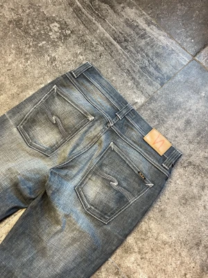 Vintage Nudie Jeans - Grim tim - tja! säljer mina heeeelt störda grims i 33/32 (sitter som 32/32)👏 otroliga fades på dessa säkert en av de snyggaste nudiesen jag sätt🫡