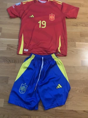 Lamine yamal jersey  - Bilderna visar ett fotbollsset med tröja och shorts från Spaniens landslag, men inga skor finns med på bilderna.