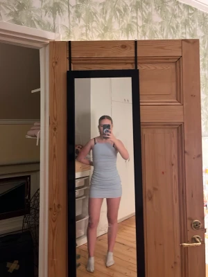 Ljusblå tight kort klänning - Säljer en ljusblå, tight och kort klänning med smala axelband. Klänningen har en enkel och stilren design som sitter figurnära och framhäver siluetten. Perfekt för dig som gillar minimalistisk stil och vill ha något som känns fräscht och somrigt. Fråga mig om ni undra något 😊