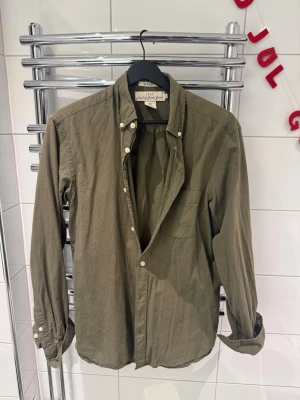 Olivgrön skjorta  - Riktigt snygg och skön retro skjorta i en unik grön färg. Skjortan är i storlek S. 