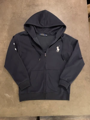 Polo Ralph Lauren zip hoodie - Big Pony - Snygg Polo zip i navy blue. Storlek M, knappt använd. Den är i nytt skick, inga skavanker på den. Vid fler frågor skicka ett pm!