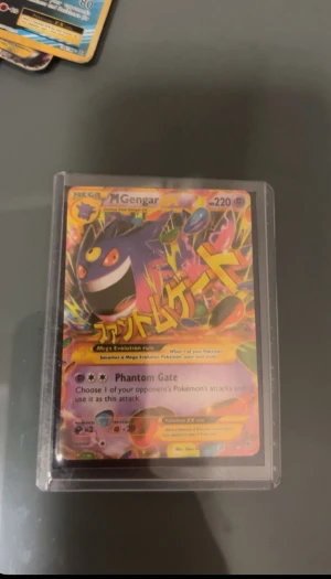 2014 Pokemon M Gengar EX Phantom Forces Ultra Rare PSA 7 Mega Evolution - Mega Gengar EX är ett samlarkort från Pokémon TCG Phantom Forces, Ultra Rare och PSA 7-graderat. Kortet har färgstark design och coola attacker som Phantom Gate. Perfekt för dig som älskar Pokémon och vill ha något riktigt unikt i din samling!