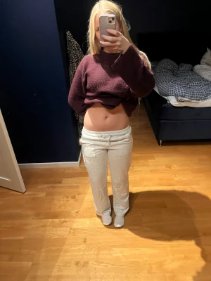 Vita mjukisbyxor med snörning - Säljer ett par vita mjukisbyxor med dragsko i midjan. Byxorna har en loose passform och raka ben.  Materialet är mjukt och skönt mot huden.