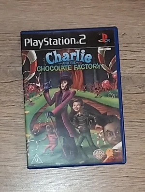 Charlie and the Chocolate Factory (PlayStation 2) - Charlie and the Chocolate Factory till PlayStation 2. Komplett med fodral och skiva i gott skick. Omslaget är färgglatt och skivan ser ut att vara i bra skick utan synliga repor. Perfekt för samlare eller fans av spelet och filmen. Meddela mig om ni har några frågor!