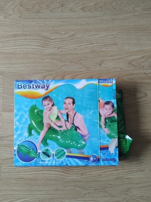 Bestway Uppblåsbar Krokodil - Rolig uppblåsbar krokodil för poolen, perfekt för barn från 3 år. Produkten är 168x86 cm och levereras i originalförpackning. Kartongen har vissa skador men innehållet är komplett och i gott skick.
