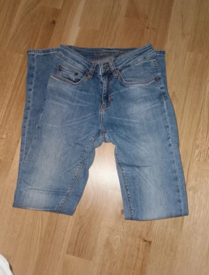 Blåa jeans från Boomerang - Snygga blå jeans från Boomerang med klassisk femficksdesign. . Modellen har normal passform och raka till smala ben, med knapp och dragkedja i gylfen. Modellen heter Elsa, storlek W25 L 32. Perfekt för dig som gillar en enkel och stilren look. Är i fint använt skick. 