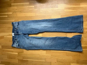 Bootcut jeans från Abandon Jeans - Snygga ljusblå bootcut jeans från A brand Jeans med klassisk femficksdesign och coola slitningar. Jeansen är utsvängda och jättelågmidjade. Köpta för 1000, nästan aldrig använda. 