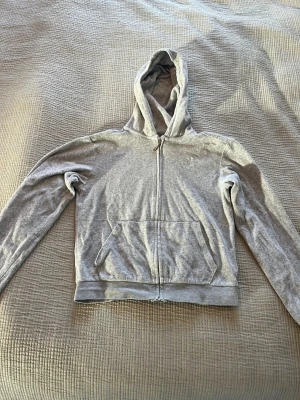 Juicy Couture - Grå hoodie med hel dragkedja och huva.