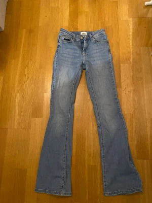Bootcut jeans i ljusblå denim från ONLY - Snygga bootcut jeans från ONLY i ljusblå tvättad denim. Klassisk femficksmodell med normal passform och hög midja. Jeansen har dragkedja och knapp framtill samt breda benslut för en cool retrostil. Passar mig som är 160 💕Skriv om ni har frågor om dem! ❤️