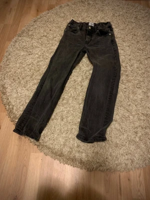 Svarta jeansbyxor storlek 150 - Svarta jeansbyxor från 157 i storlek 150. Klassisk femficksmodell med raka ben och knappstängning. Jeansen har en mörk tvätt och är tillverkade i slitstarkt denimtyg som passar perfekt till en chill och enkel stil.