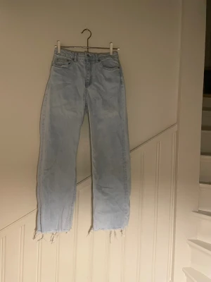 Ljusblå jeans från 157, storlek S - Ljusblå jeans från 157 i rak modell med hög midja. Jeansen har råa, fransiga benslut och klassisk femficksdesign. Tillverkade i denim av bomull, perfekta för en avslappnad och trendig look.