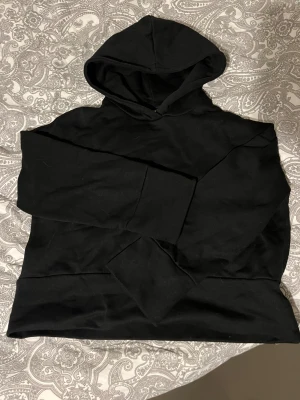 Svart hoodie - En svart hoodie med luva, långa och breda ärmar. Storlek M