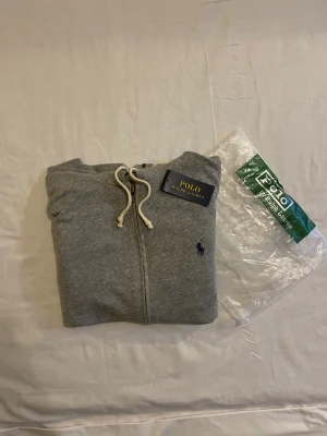 Grå hoodie från Polo Ralph Lauren - Säljer en jätte snygg grå zip ifrån Ralph Lauren. Den är i toppen skick med inga hål. Skriv till mig vid intresse❤️ Obs påsen tillkommer inte 