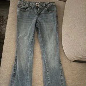 Blå bootcut jeans från Gina Tricot - Snygga blå bootcut jeans från Gina Tricot, modell Perfect Jeans. Klassisk femficksdesign, ljus tvätt och dekorativa sömmar på bakfickorna. Jeansen har normal passform och är tillverkade i mjukt denimtyg. Köpte dessa i somras men har använts 4 gånger, köpte dessa för 500 drf kommer de lägsta pris ligga på 250.(säljer dessa för att de har blivit för stora)