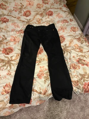 Svarta Levi's 501 jeans W32 L32 - Svarta Levi's 501 jeans med klassisk rak passform och fem fickor. Jeansen har en snygg, enkel look och är tillverkade i slitstarkt denim. Perfekt för dig som gillar tidlös stil och vill ha ett par jeans som funkar till allt.