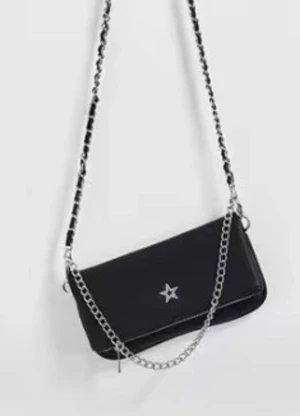 Svart axelväska med kedja och stjärna - Cool svart axelväska med silverfärgad kedjerem och en liten stjärndetalj framtill. Väskan har en avlång form och är perfekt för att bära det viktigaste. Materialet ser ut som skinn och kedjan ger en edgy vibe.