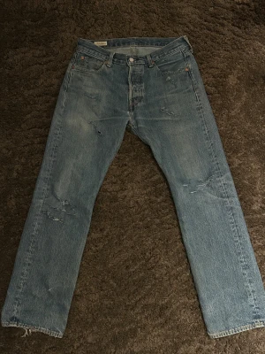 Levi's 501 jeans med slitningar - Jag har ett par Levis 501:or - W30/L30 som jag har för hand gjort egna slitningar på och de blev riktigt snyggt, jag säljer de för att jag har ögonen på ett par andra jeans som jag inte har råd med! Byxorna sitter som regular fit som är storlek 30/30 Priset kan diskuteras!!