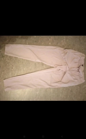 Beige mjukisbyxor med snörning - Snygga beige mjukisbyxor med elastisk midja och snörning framtill. Byxorna har en relaxed passform och är gjorda i mjukt material som är perfekt för chill dagar. Passar dig som gillar enkel och clean stil.