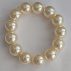 Pärlarmband med stora vita pärlor - Säljer ett elegant armband med stora, glansiga vita pärlor. Perfekt accessoar för att lyfta din outfit med en klassisk och tidlös känsla. Elastiskt band gör det enkelt att ta på och av. Tillverkat armbandet själv med köpta pärlor