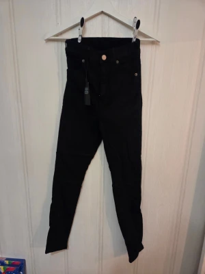 Svarta Moxy Petite jeans från Dr Denim - Svarta Moxy Petite jeans från Dr Denim med hög midja och smal passform. Klassisk femficksmodell med knapp och dragkedja framtill. Aldrig använda utan enbart testade. Rätt liten i storleken, kan förekomma lite djurhår. Nypris 599kr men säljes för 200kr