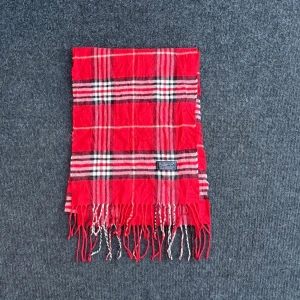 Burberry scarf - Burberry-scarf som är 100% äkta. Mindre defekter kan förekomma enligt bild men inget märkvärdigt då de är vintage. Snabb leverans och trygg handel då vi har 7 års erfarenhet i branschen. Vid frågor eller bud, skicka gärna ett meddelande. 1012