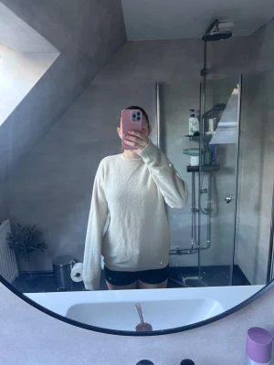 Vit stickad tröja med lång ärm - Mysig vit stickad tröja med rund hals och långa ärmar. Enkel och clean design som är lätt att matcha med olika outfits. Perfekt för dig som gillar en chill och stilren look.