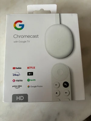 Chromecast with Google TV (HD) - Streama dina favoritappar som YouTube, Netflix och Disney+ med Chromecast with Google TV (HD). Enkel installation, röststyrd fjärrkontroll, stöd för 1080p HDR och HDMI. Kompatibel med Android och iOS. Produkten är i nyskick, originalförpackning medföljer.