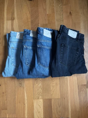 Zara Jeans Straight Fit (4 par!!!) - Säljer 4-par klassiska Zara Jeans Straight Fit i olika tvättar, från ljusblå till mörkblå och svart. Modellen har raka ben, fem fickor och knappgylf. Jeansen är tillverkade i slitstarkt bomullsdenim och har den ikoniska vita Zara-lappen bak i midjan. Storlek 38.