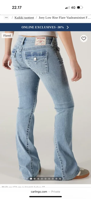 True Religion ljusblå bootcut jeans - Ljusblå jeans från True Religion med bootcut och låg midja. Klassiska bakfickor med broderad logga och silverfärgade knappar. Jeansen är i denim och har slitna detaljer vid bensluten för en extra avslappnad vibe.