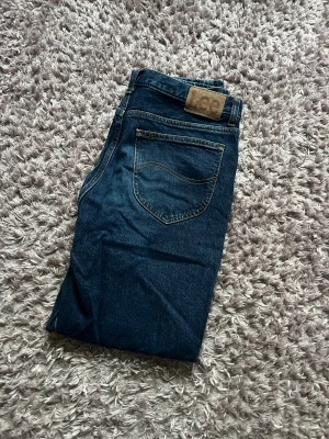 Mörkblå Lee jeans Oscar W33 L32 - Snygga mörkblå jeans från Lee, modell Oscar. Klassisk design med Lee-lapp bak i midjan och kontrastsömmar. Raka ben och normal passform, tillverkade i slitstarkt bomullsmaterial. Perfekta för dig som gillar tidlös denimstil. Hör av er vid frågor och för fler bilder. Billigare vid snabb affär 😊