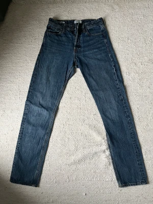 Blå jeans Jack & Jones - Säljer ett par blå jeans från Jack & Jones, modellen Relaxed Chris. De har klassisk femficksdesign, raka ben och normal passform. Jeansen är tillverkade i slitstarkt denim med snygga kontrastsömmar och ett beige läderpatch bak i midjan.