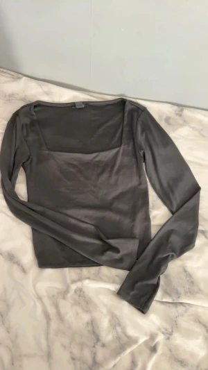 Svart och vit långärmad tröjor - Två stilrena långärmade toppar i svart och vitt. Båda har en fyrkantig halsringning och är croppade i modellen. Materialet är mjukt och stretchigt, perfekt för att skapa en clean och modern look. Säljes tillsammans eller separat!