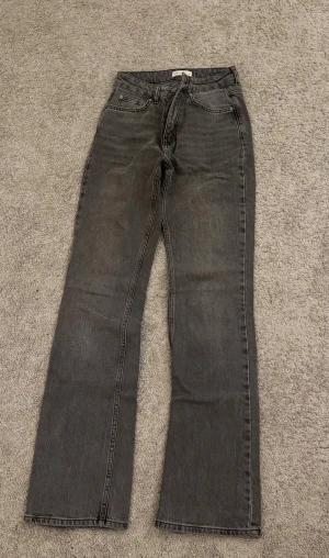 Svarta/mörk grå bootcut mid waist jeans - Mid waist grå/svarta jeans från Gina tricot, säljer för att dom är för små.