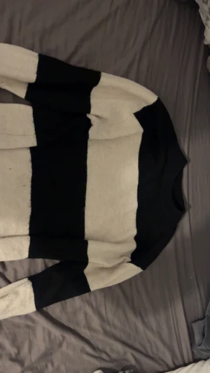 Svartvit randig stickad tröja H&M - Säljer en stickad tröja från H&M i storlek XS med breda svarta och vita ränder. Tröjan har rund hals, ribbade muddar och långärmade ärmar. Perfekt för dig som gillar en chill och enkel stil med lite edge.